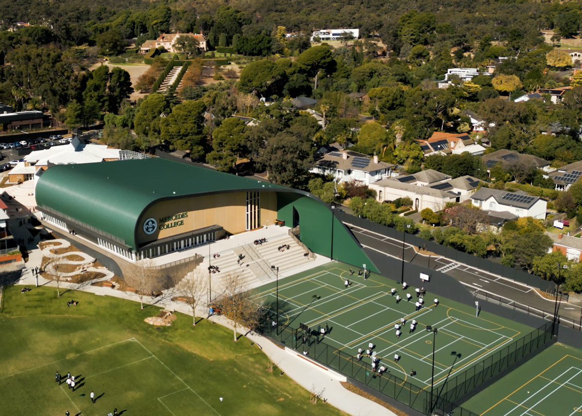 Aerial view of Mercedes College in Adelaide, showcasing modern sports courts, the new arts and sports centre, and surrounding residential area.