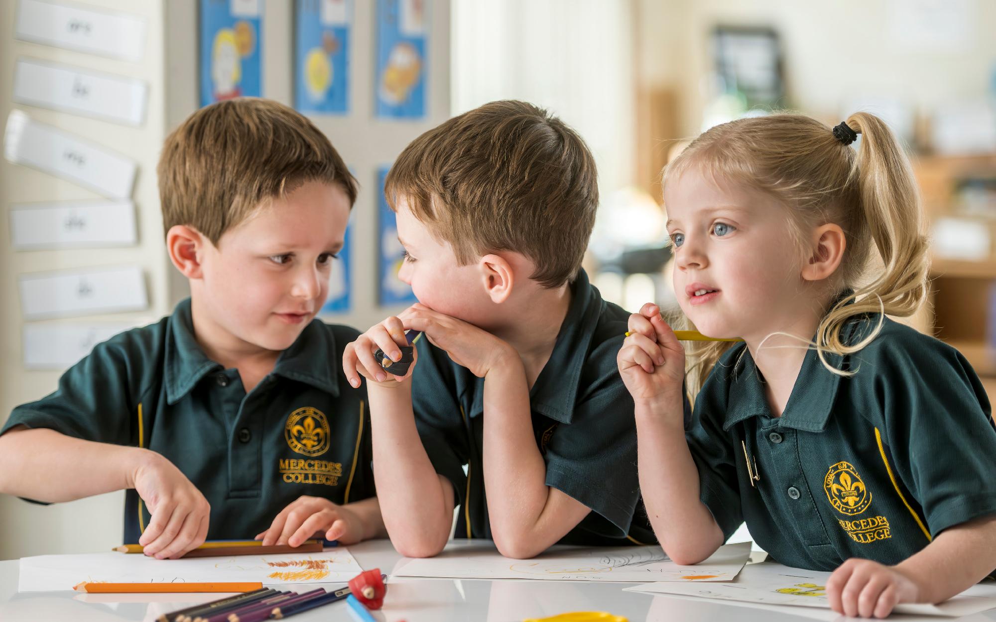 Mercedes College Junior School students drawing and colouring together in a bright classroom.