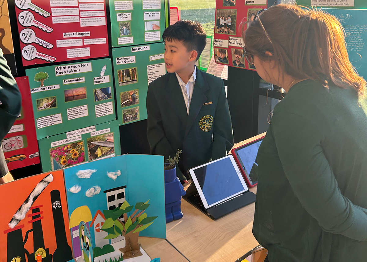 Mercedes College student presenting his sustainability project display to a visitor.